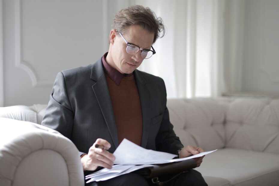 Man reading documents while sitting on a coach